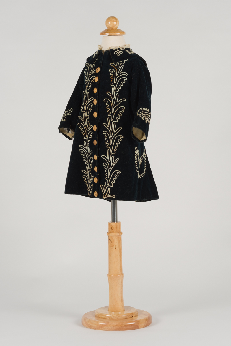child's coat, black with beige embroidered flowers, close eooden buttons go up the centre of the coat