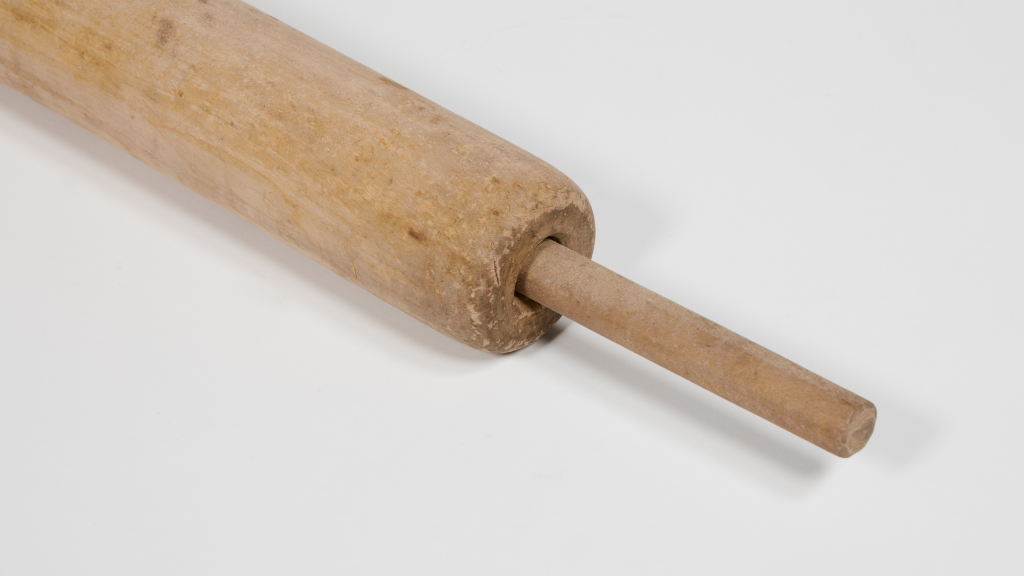 Close up of pale wooden rolling pin with long thin handles