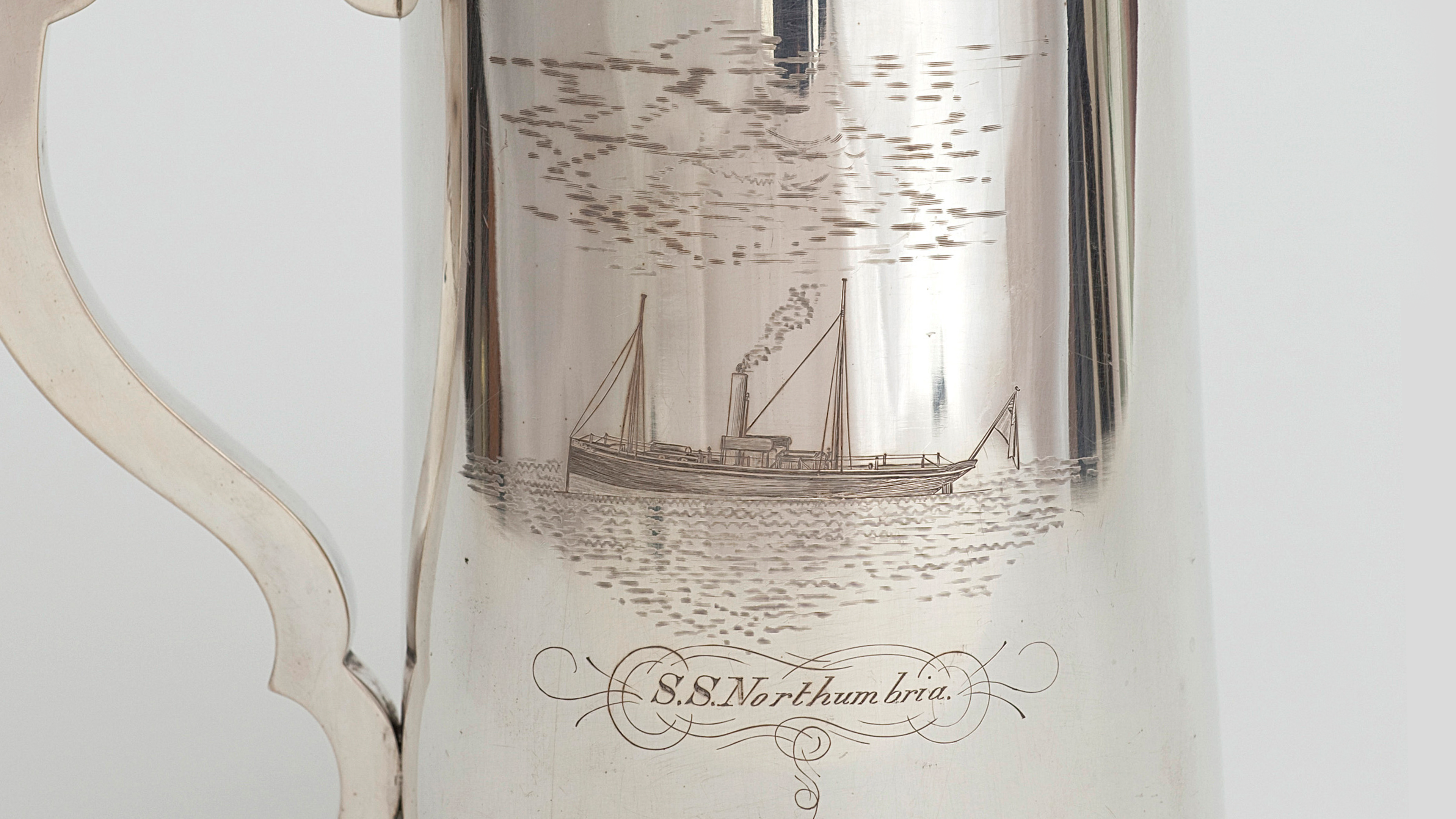 silver mug etched with a boat labelled 'S.S Northumbra'