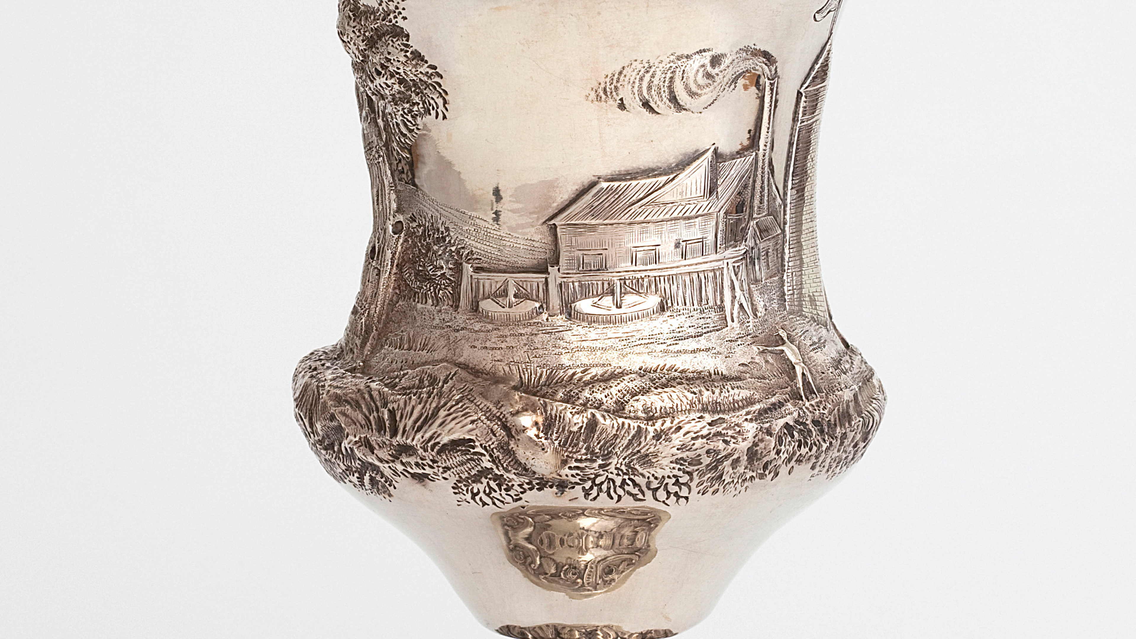 Silver goblet etched with a placid illustration of a refinery