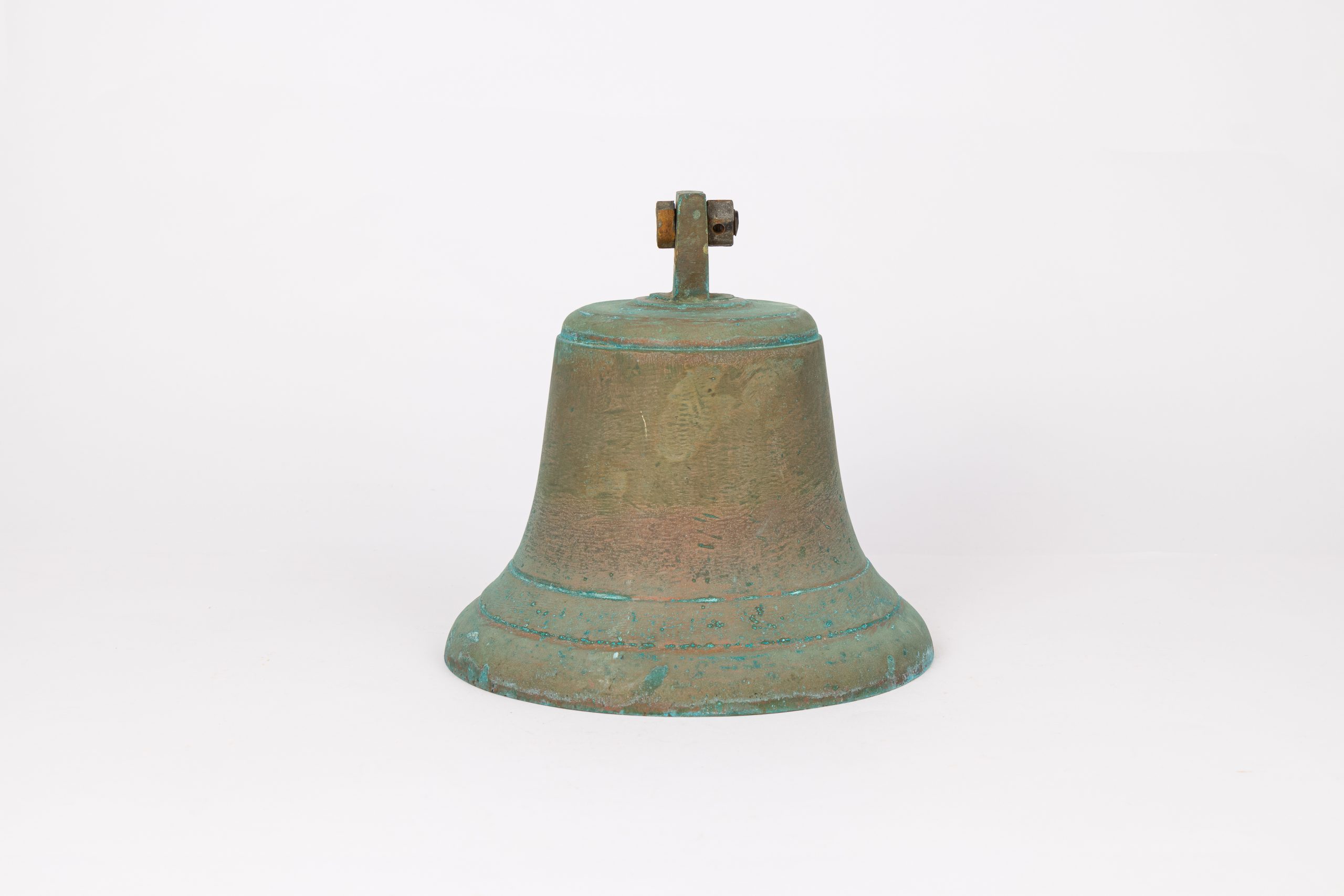Brassy metal bell with green oxidisation