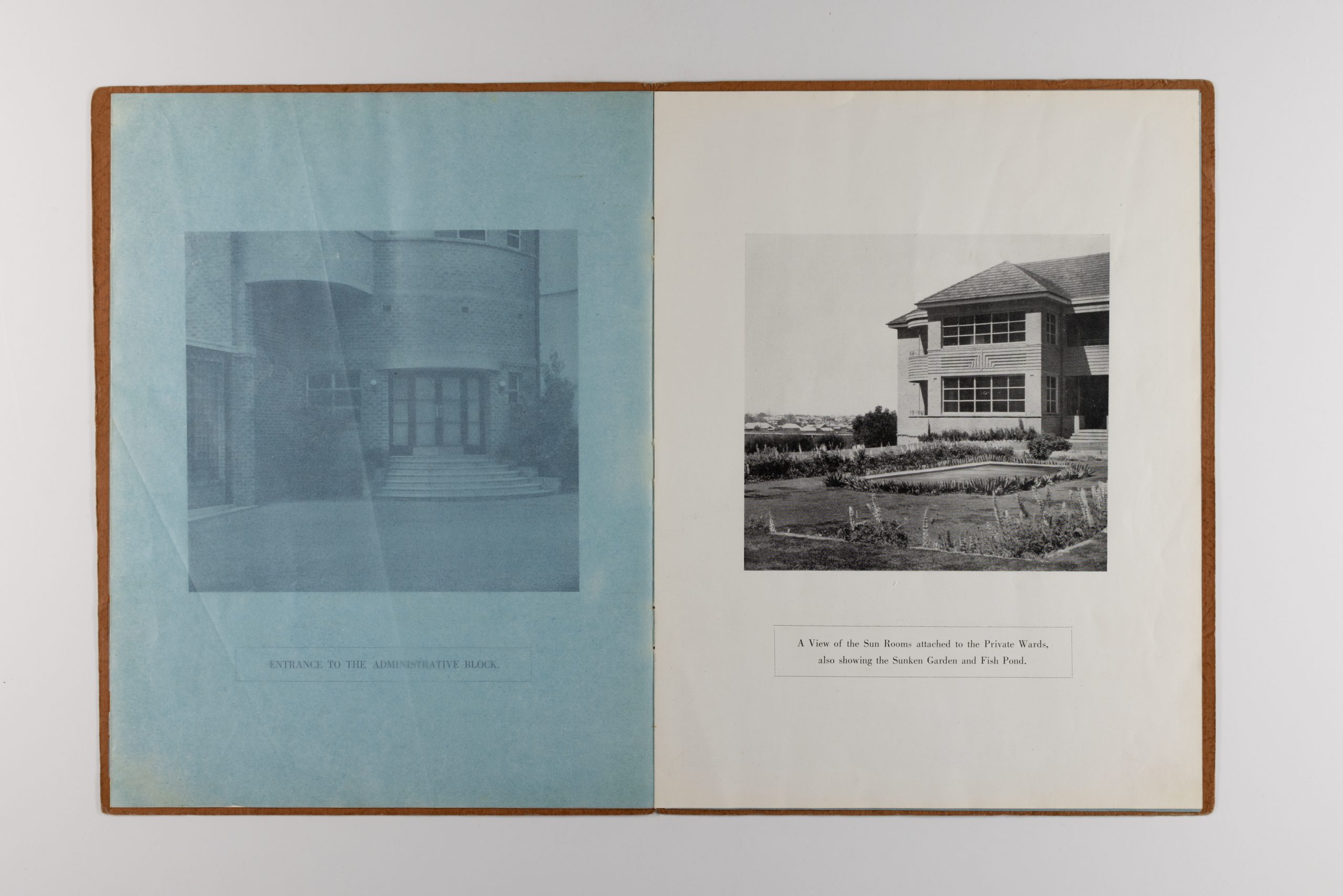 open pages of booklet, the left page is a semi-transparent blue page, the right page is a 'a view of the sun rooms attached to the Private Wards, also showing the Sunken Garden and Fish Pond.'