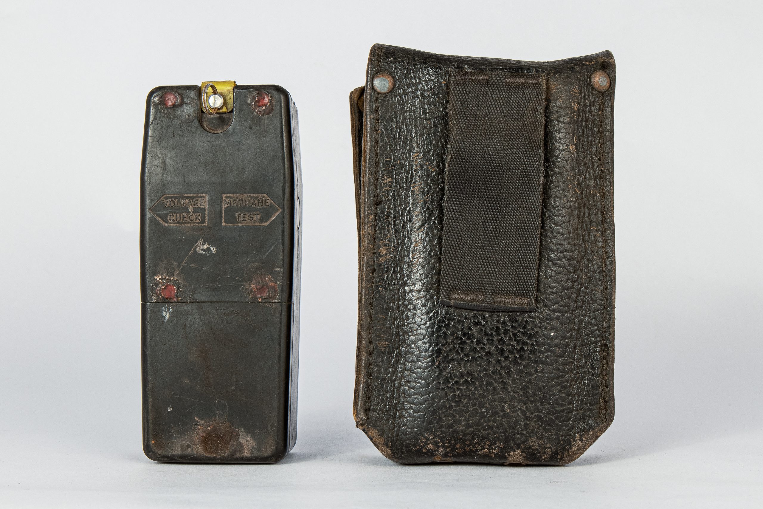 Back of device shaped like an old Nokia mobile phone. Beside it is a leather pouch to hold the device.