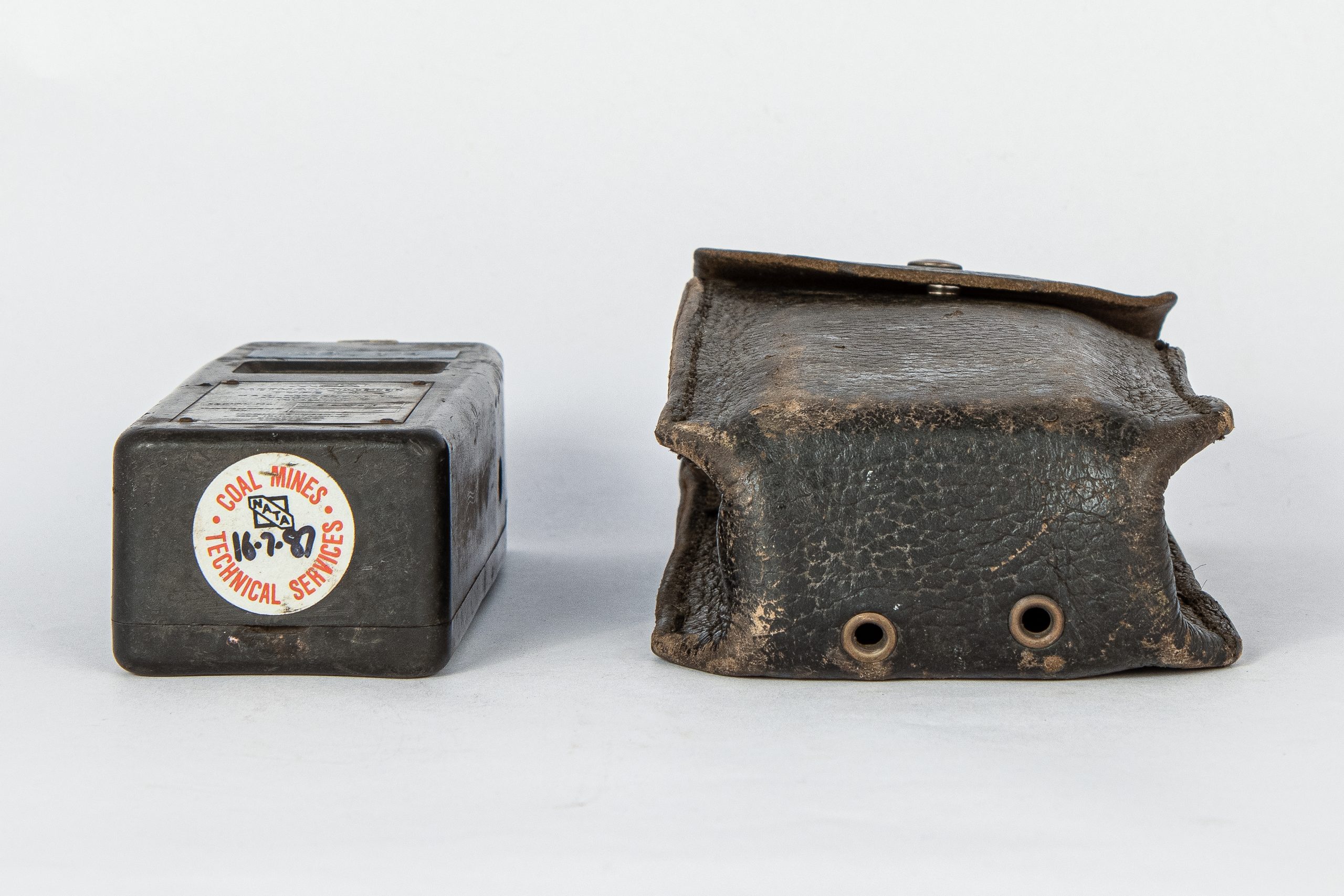 Bottom of device shaped like an old Nokia mobile phone. A sticker on the bottom reads, "COAL MINES TECHNICAL SERVICES NATA 16-7-87." Beside it is a leather pouch to hold the device.