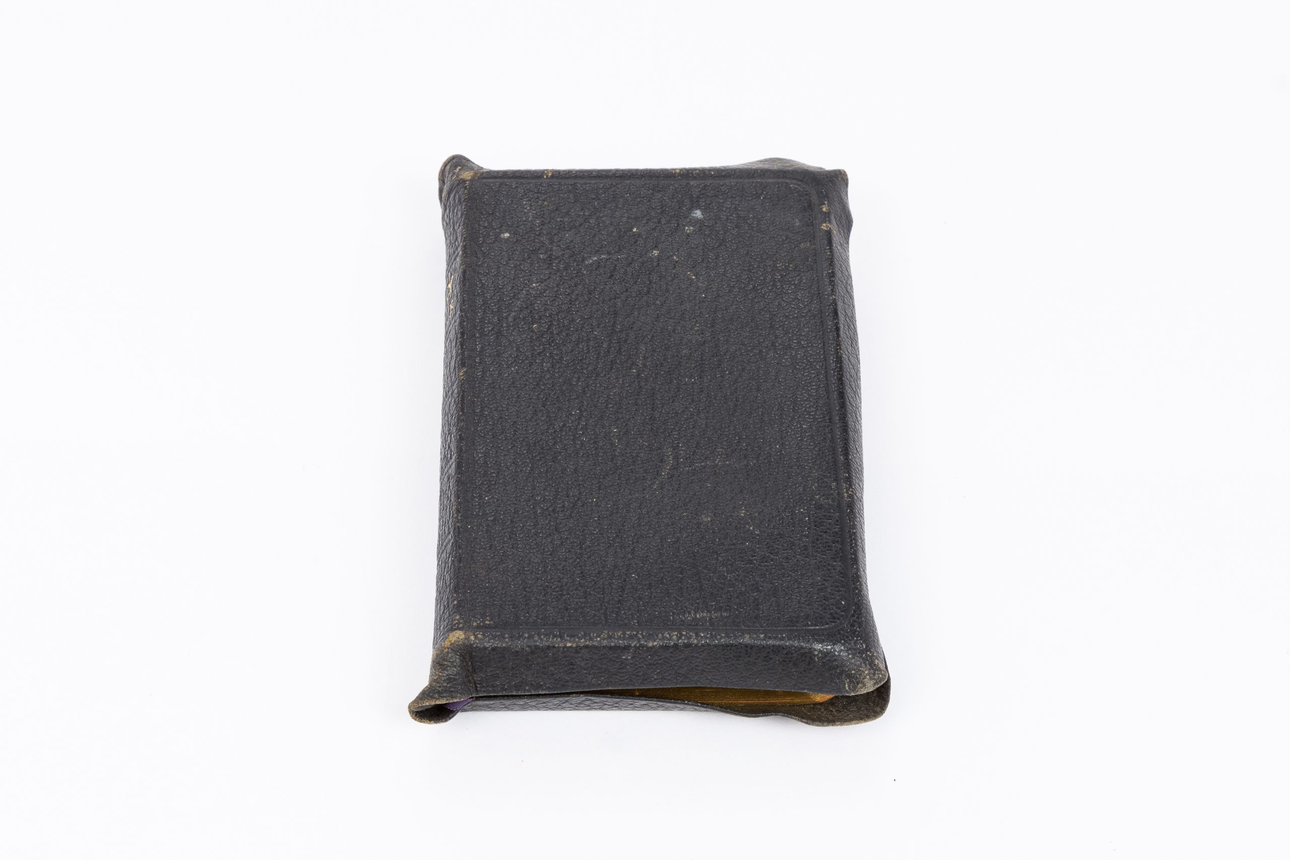 Black, leather-bound bible which is slightly tarnished