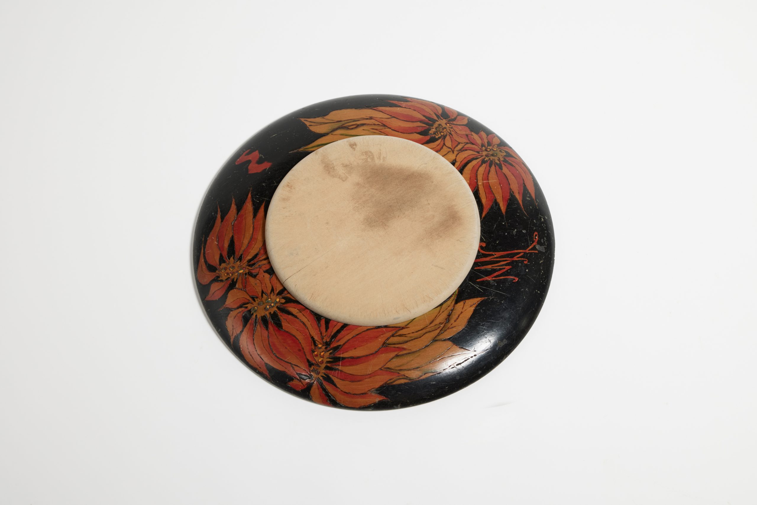Circular breadboard with chopping board; design of poinsettia flowers burned into the wood
