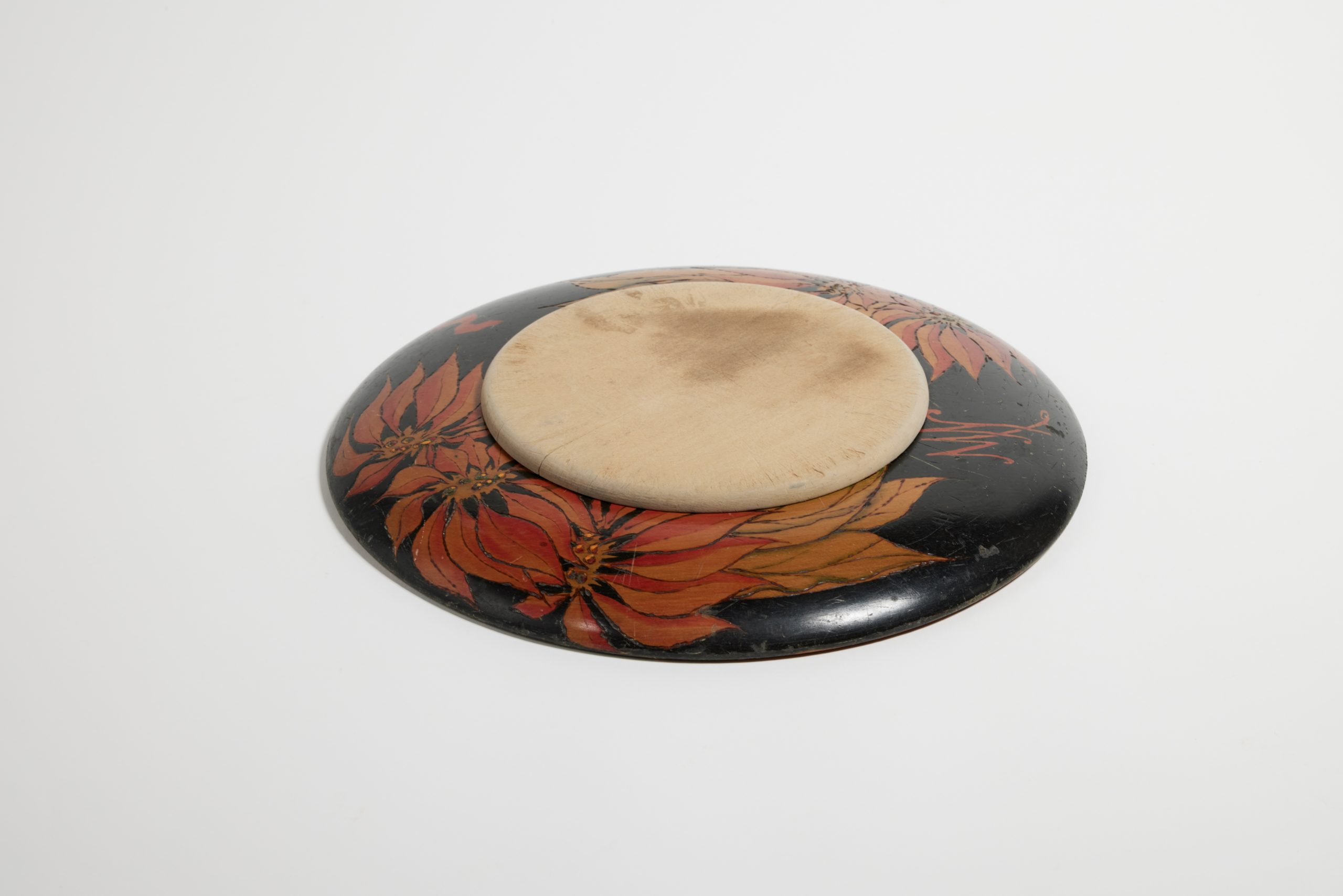 Circular breadboard with chopping board; design of poinsettia flowers burned into the wood