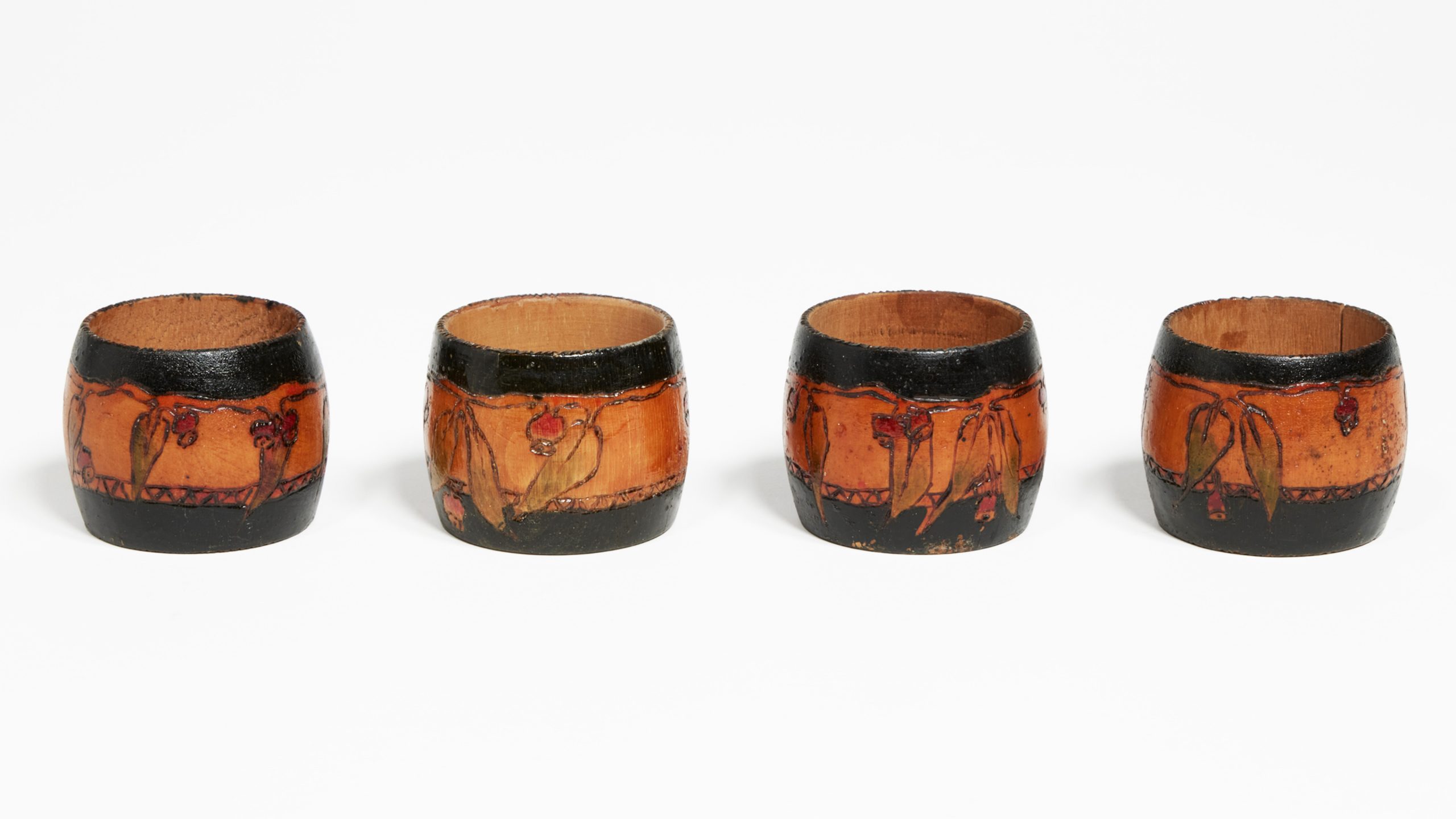 Four wooden napkin rings with gumnuts and black bands burned into them