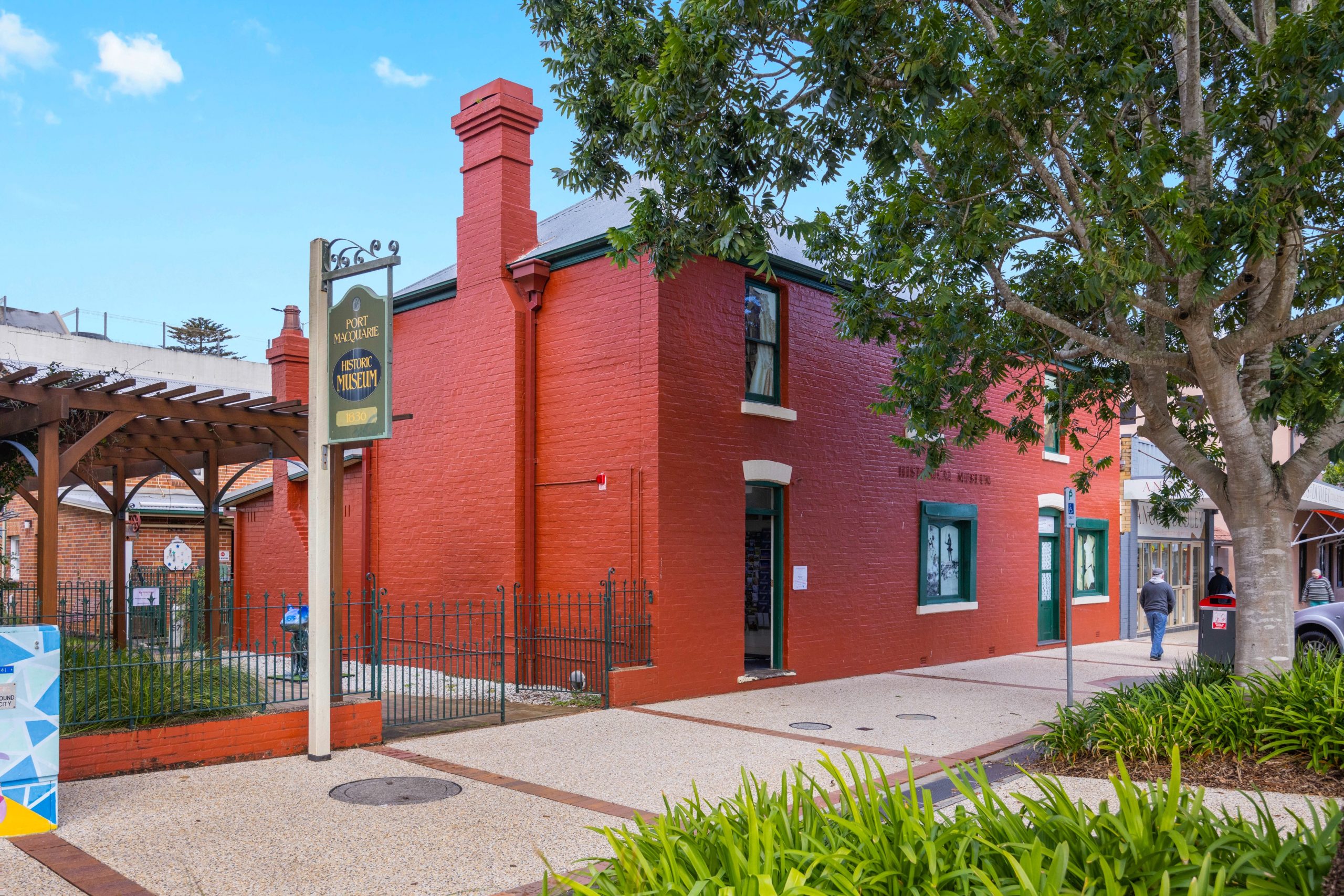 Brick building painted entirely bright red with dark green details