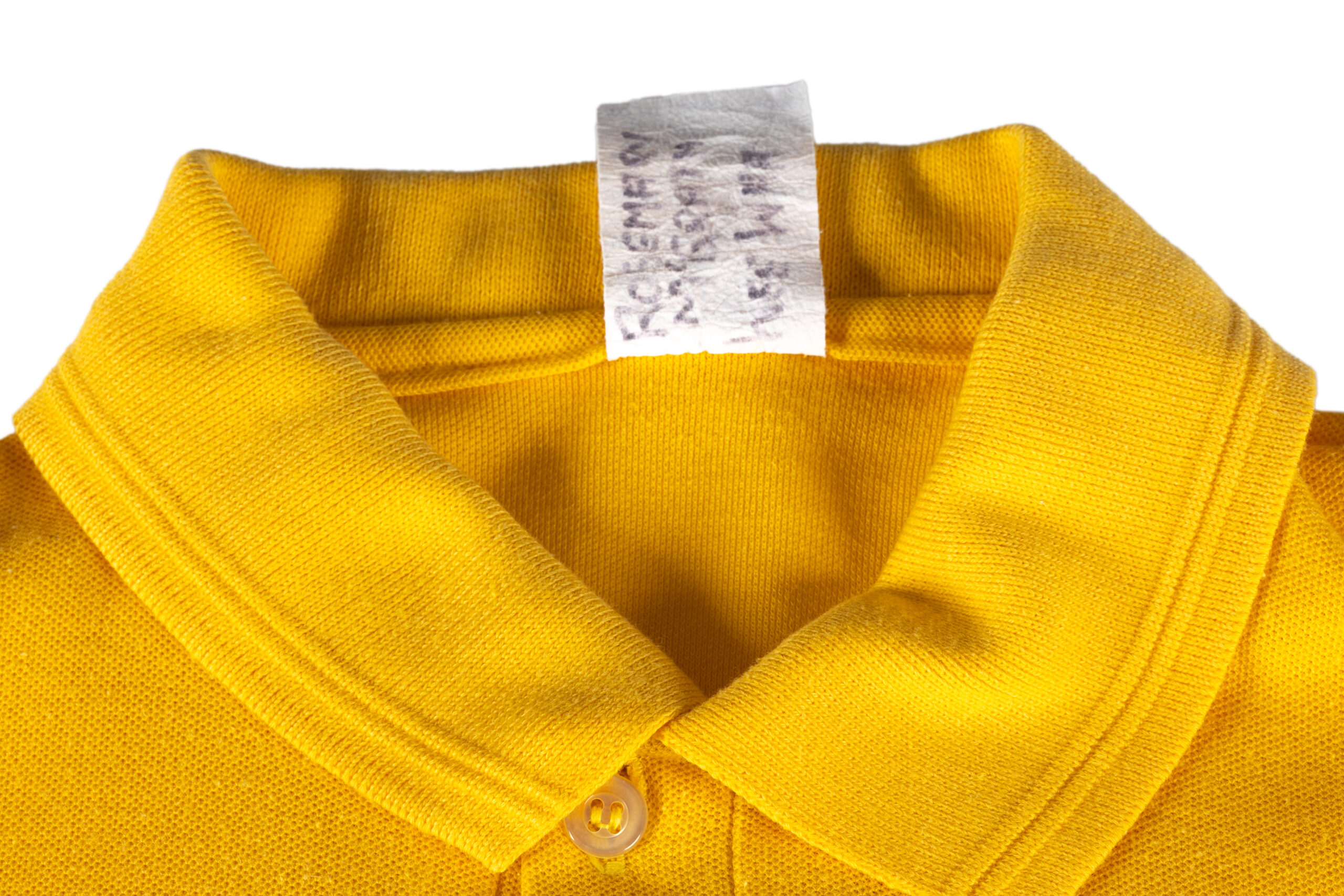 detail of yellow polo shirt collar, the tag has a faded marker writing which reads 'ROSEMARY MCGRATH WEE WAA'